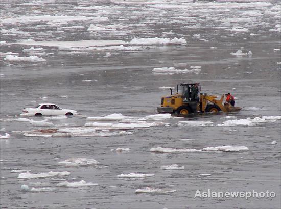 Car stranded on flooded river bank