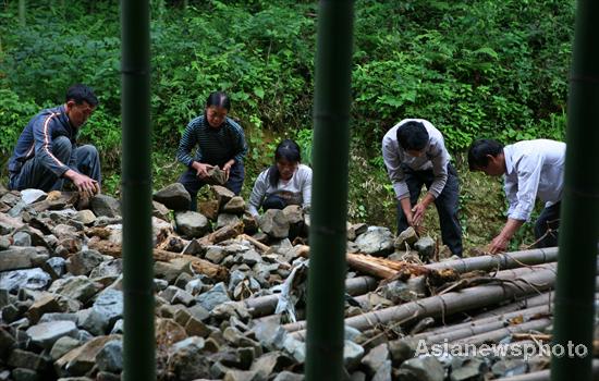 Villagers rebuild sole road after flood