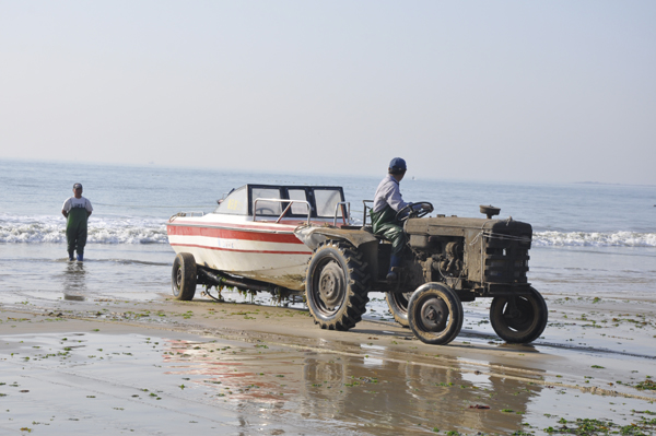 Tractor gives a speed boat a jump start