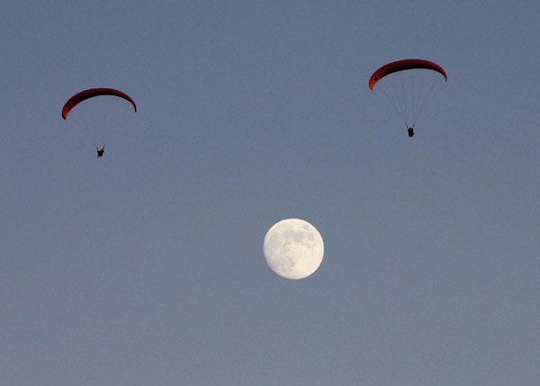Paragliders sail above moon