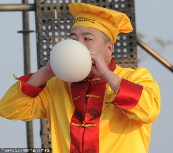 Pastry master blows dough balloon