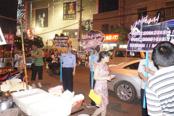 Officers hold slogan placards for urban management