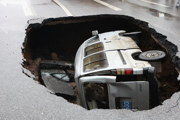 Car falls in as road in S China caves in