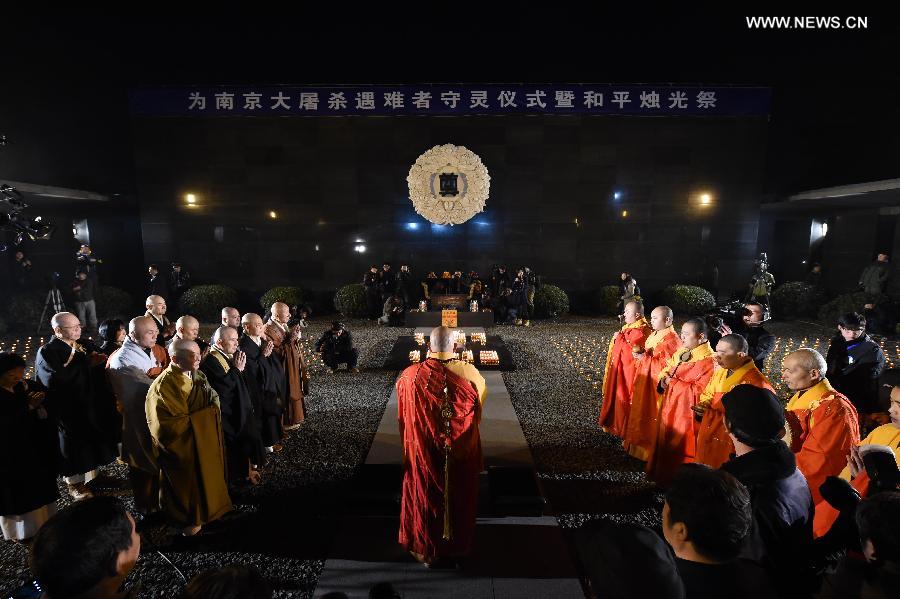 People hold candles to mourn victims of Nanjing Massacre