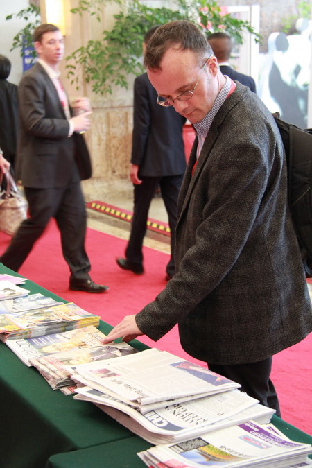 A visitor reads China Daily newspaper at Routes Asia 2015 on March 16