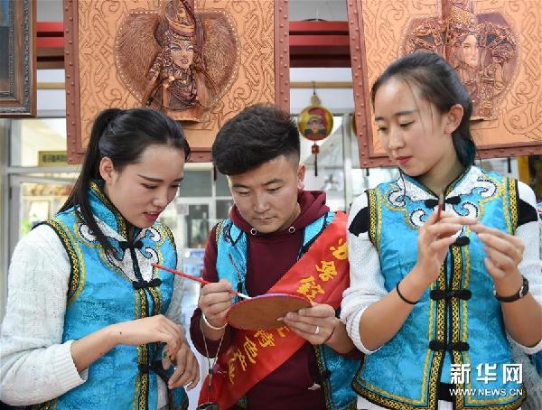 Young people enjoy Inner Mongolian leather painting
