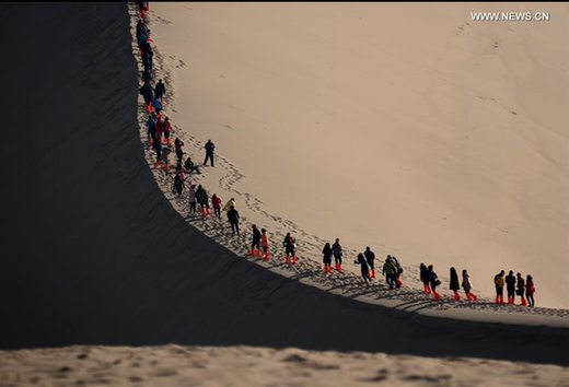 Tourists visit Mingsha Mountain in NW China's Dunhuang