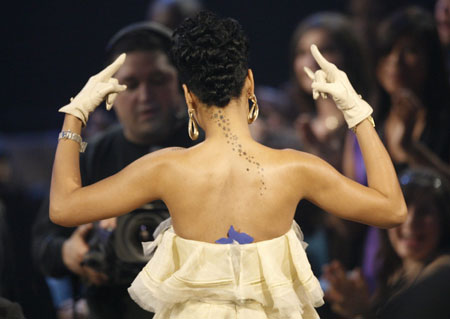 Rihanna stands up in the crowd after winning her second award