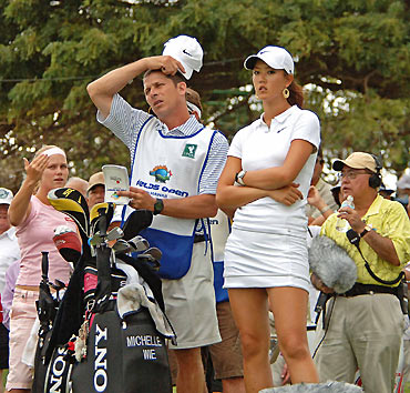 Michelle Wie of Honolulu, Hawaii, and her caddie Greg Johnston stand at the 16th hole during Round 2 of the Fields Open at the Ko Olina Golf Club, on the island of Oahu in Kapolei, Hawaii February 24, 2006. At left is golfer Minea Blomqvist of Finland. [Reuters]