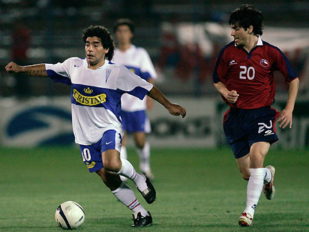 Argentine soccer legend Diego Maradona (L) controls the ball as Jaime Valdes(R) follows during a soccer between the teams La Chile and Universidad Catolica, to help the Union of professional soccer players, at San Carlos de Apoquindo stadium in Santiago March 1, 2006. [Reuters]