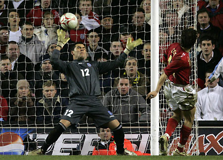 England's Joe Cole (R) scores against Uruguay's Sebastian Viera (L) during their international friendly soccer match at Anfield in Liverpool, northern England March 1, 2006. [Reuters]