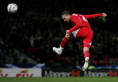 Switzerland's Daniel Gygax scores against Scotland during their friendly soccer match at the Hampden Park stadium in Glasgow, Scotland March 1, 2006. [Reuters]