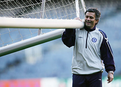 Chelsea manager Jose Mourinho helps to carry goalposts during a training session at the Nou Camp stadium, Barcelona March 6, 2006. Chelsea are due to play Barcelona in their Champions League first knockout round second leg soccer match on March 7, 2006