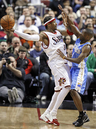 Philadelphia 76ers guard Allen Iverson (L) holds off the defensive efforts of Denver Nuggets guard Earl Boykins during second quarter NBA action in Philadelphia March 9, 2006. [Reuters]