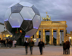 People walk past a giant 2006 FIFA World Cup globe next to Berlin's landmark Brandenburg Gate May 31, 2006. The 15-metre high soccer globe was created by Vienna-based cross-disciplinary artist Andre Heller. [Reuters] 