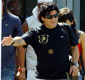 Argentina's former soccer player Diego Maradona waves to fans as he leaves the hotel after visiting the Argentine team in Herzogenaurach June 12, 2006. 