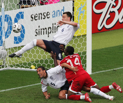 England's John Terry makes a clearance in front of team mate Rio Ferdinand (5) and Trinidad and Tobago's Stern John (14) watch during their Group B World Cup 2006 soccer match in Nuremberg June 15, 2006. [Reuters]