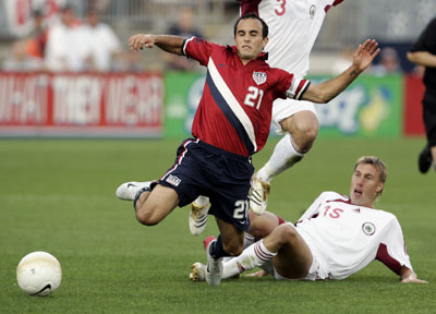 Midfielder Landon Donovan (L) of the U.S. is tackled by midfielder Genadijs Solonicins of Latvia in the first half of their international friendly soccer match at Rentschler Field in East Hartford, Connecticut May 28, 2006. 