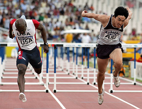 World record holder Liu Xiang(R) and Allen Johnson clear a hurdle at the men's 110-meter hurdles race of the IAAF World Cup in Athens on September 17, 2006. Liu finished second as Johnson won the race.[Xinhua]