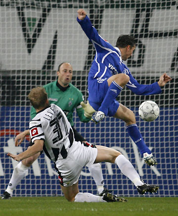 Borussia Moenchengladbach's Tobias Levels (L) challenges with Schalke 04's Danish Peter Loevenkrands (R), while goalkeeper Kasey Keller watches during their German Bundesliga soccer match in Moenchengladbach November 8, 2006. 