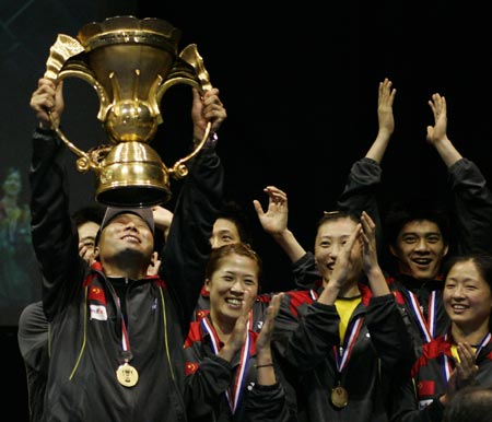 Chinese badminton team coach Lee Yong Bo (L) holds aloft the winner's trophy after the final of the Sudirman Cup World Team Badminton Championships in Glasgow, Scotland June 17, 2007. 