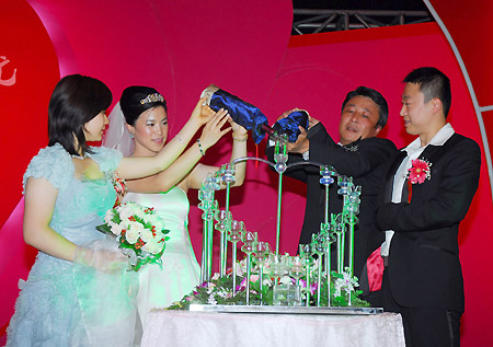 China's four-time Olympic table tennis gold medalist Wang Nan (2nd L) pours Champagne into glasses at her wedding with long-time partner Guo Bin onboard a luxury yacht in Yantai, Shandong Province, September 27, 2008. Wang's teammate Ma Lin (R), the reigning Olympic men's singles champion, and Japan's most popular table tennis star Ai Fukuhara (L) were best man and maid of honor respectively. [Xinhua]