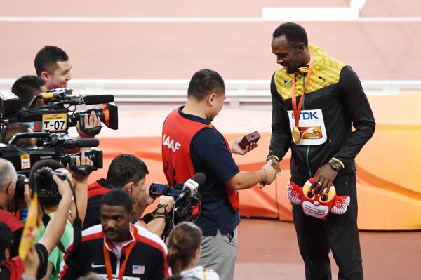 Bolt receives lucky 'sorry' bracelet from fallen cameraman