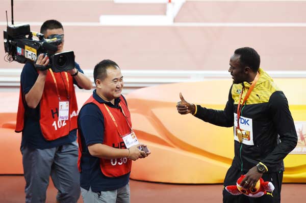 Bolt receives lucky 'sorry' bracelet from fallen cameraman