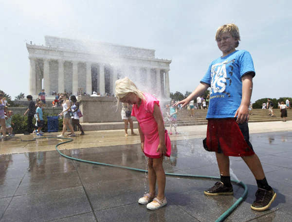 Children play with sprays of water in Washington