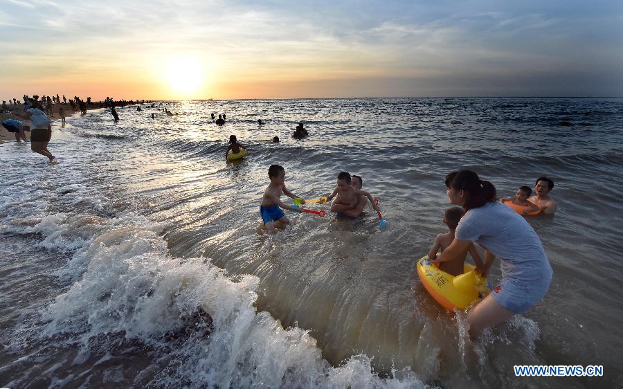 Haikou citizens play along beach in heat wave