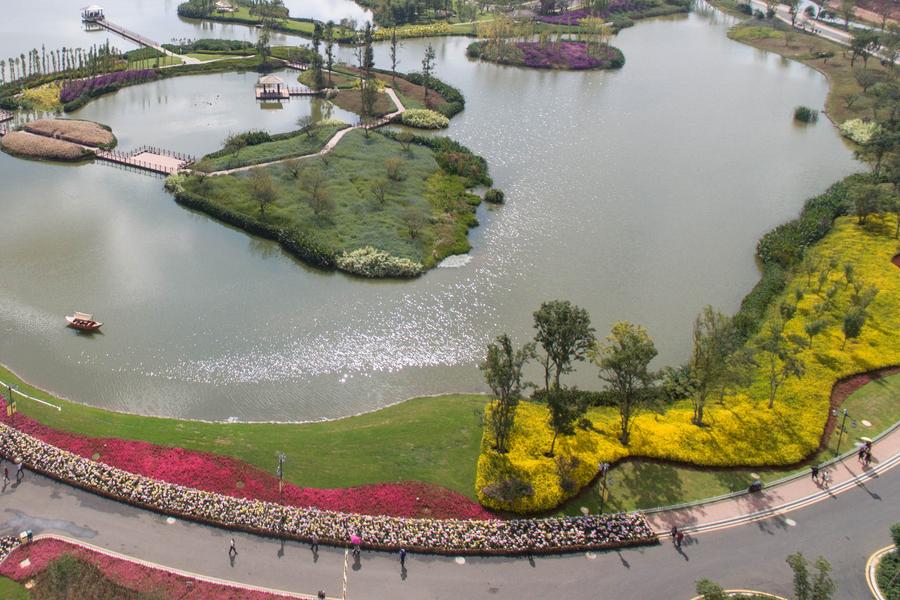 Tourists go sightseeing at Gudian wetland park in Kunming