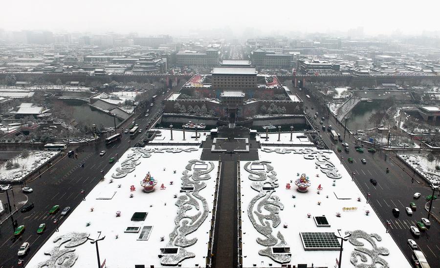 People enjoy snow scenery of ancient city Xi'an