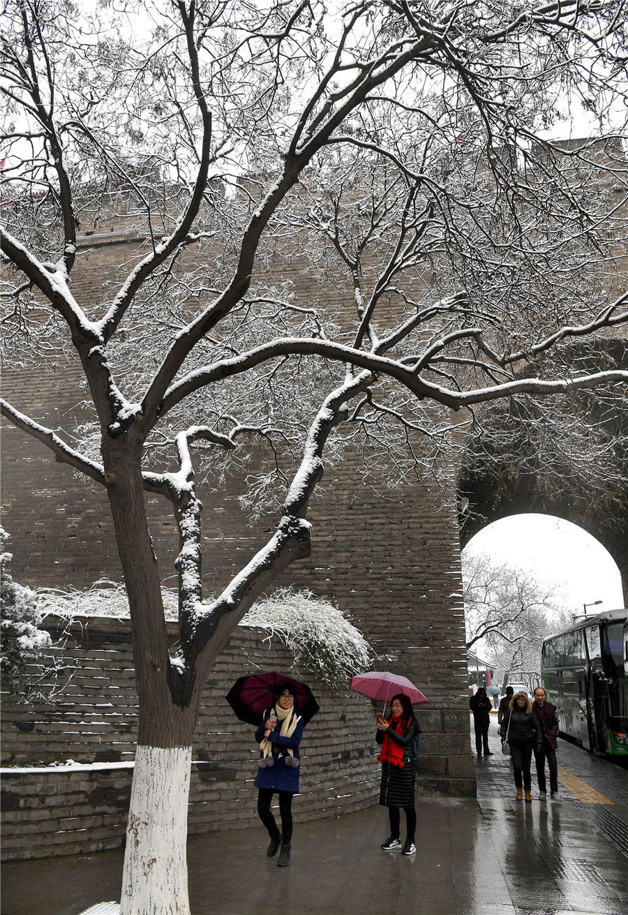 People enjoy snow scenery of ancient city Xi'an