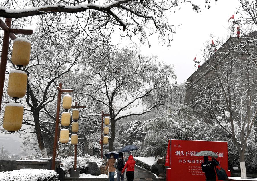 People enjoy snow scenery of ancient city Xi'an