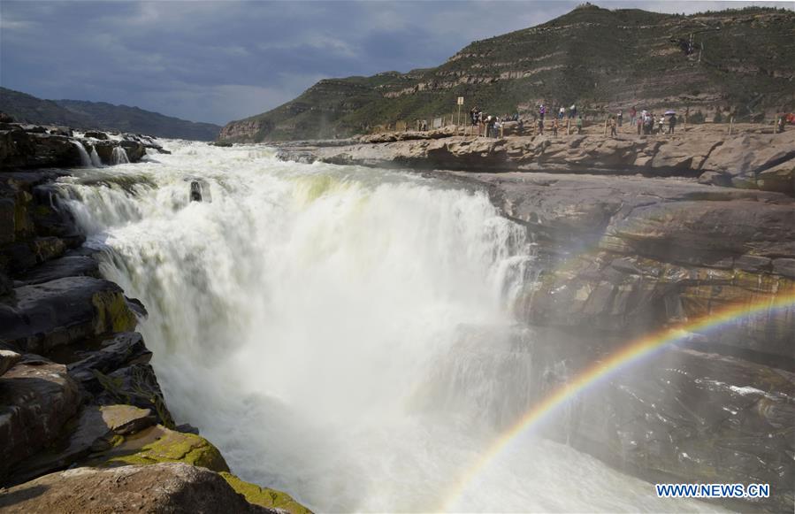 Visitors view Hukou Waterfall in N China