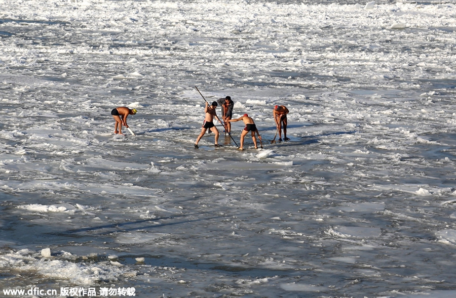 Swimmers battle against the cold in ice-covered river