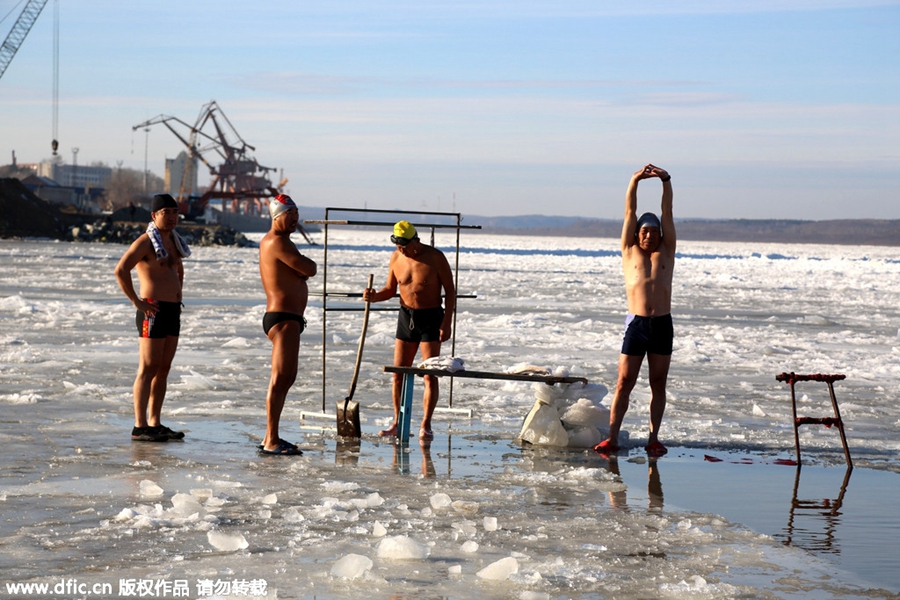 Swimmers battle against the cold in ice-covered river