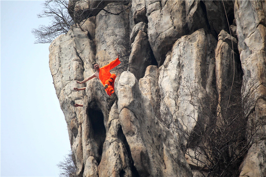 Martial artists practice Shaolin kung fu on cliff