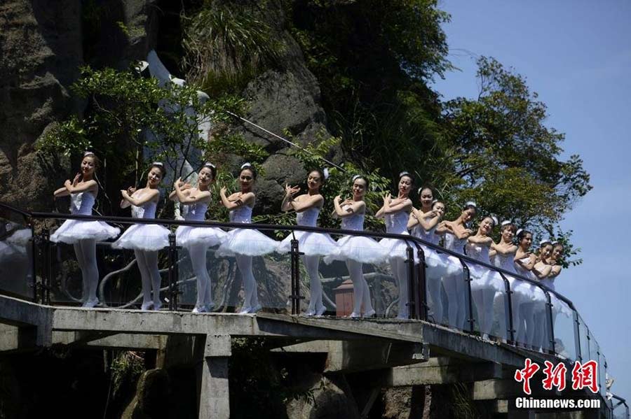 Dancers perform ballet on cliff, glass walkway