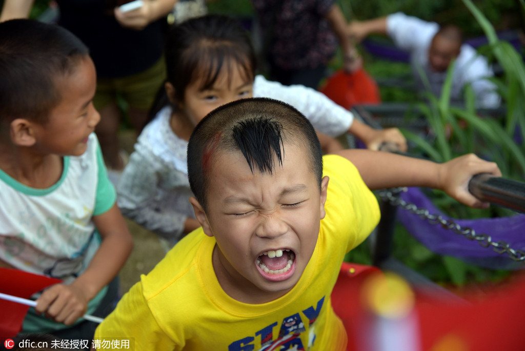 Fathers use bamboo strips to steer children on cliff walkway