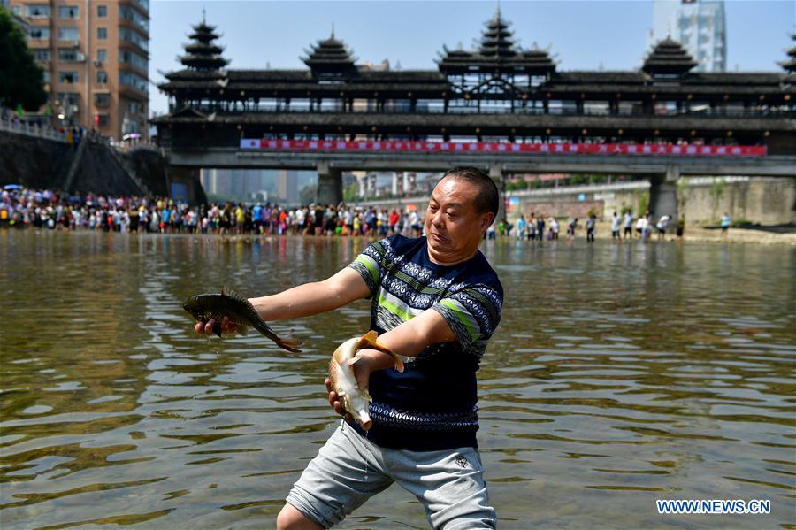 People catch fish in river to celebrate good harvest