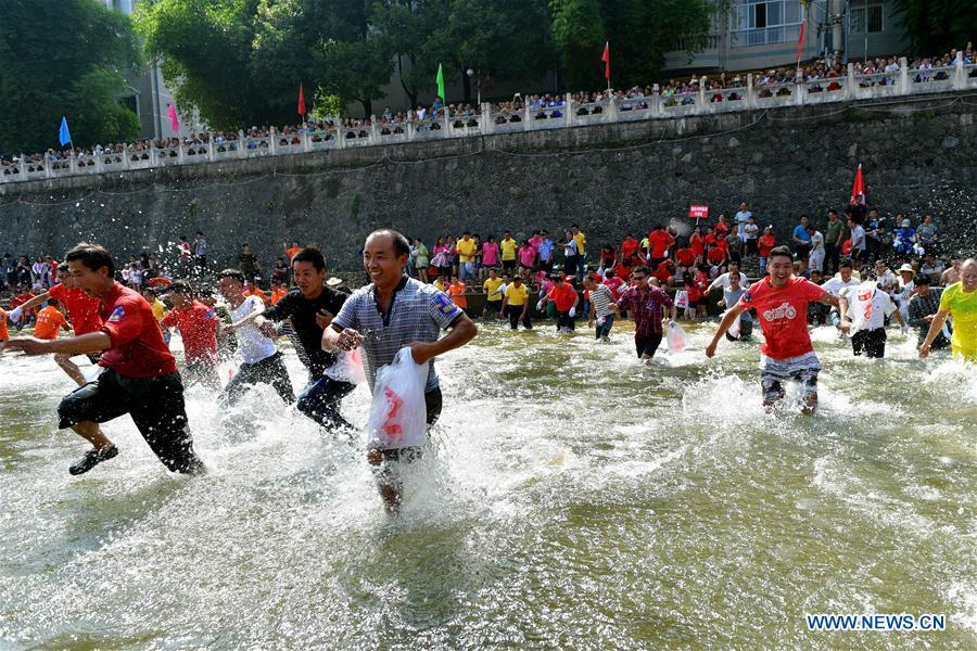 People catch fish in river to celebrate good harvest