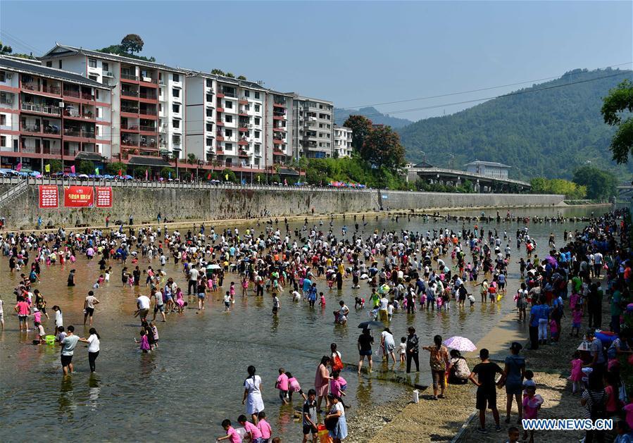 People catch fish in river to celebrate good harvest