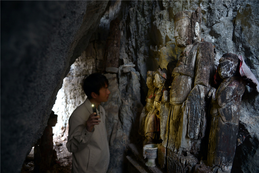 Wood sculptures discovered inside cliffside cave in Chongqing