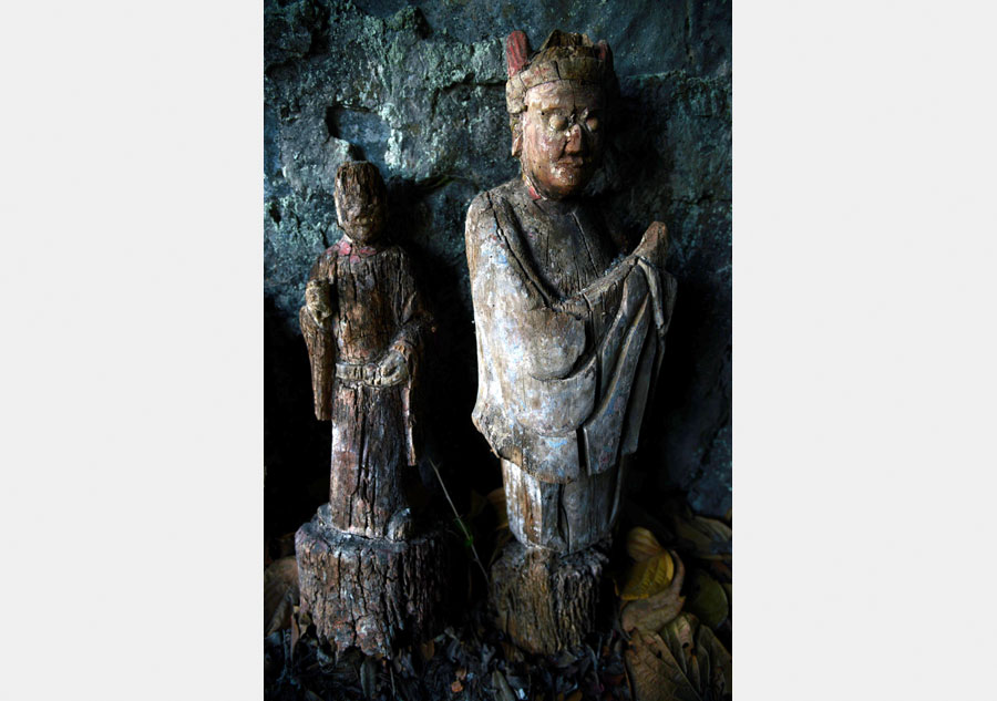 Wood sculptures discovered inside cliffside cave in Chongqing