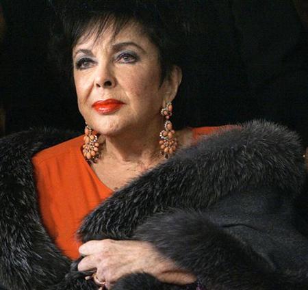 Elizabeth Taylor improving, but remains in hospital