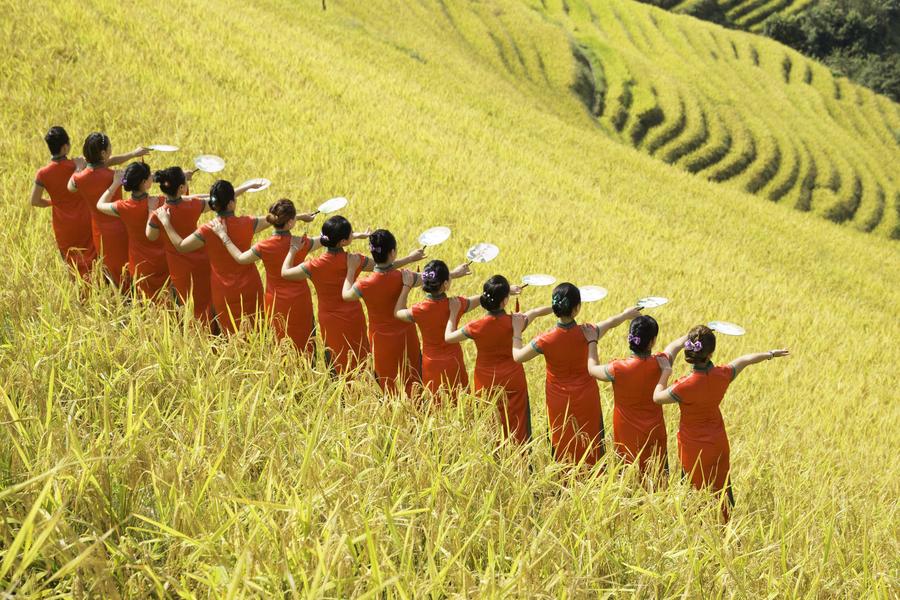 Women present cheongsam at Ping'an terrace field in Guangxi