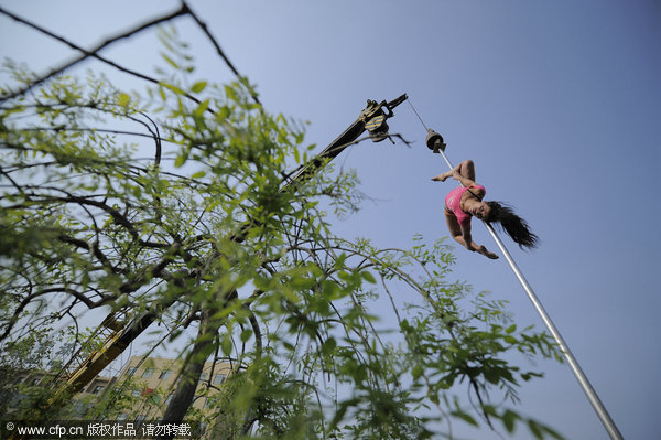 Crane hoists pole dancers in air