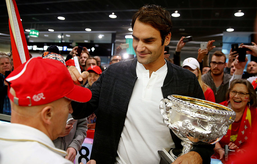 Trophy-holding Federer receives hero's welcome back home