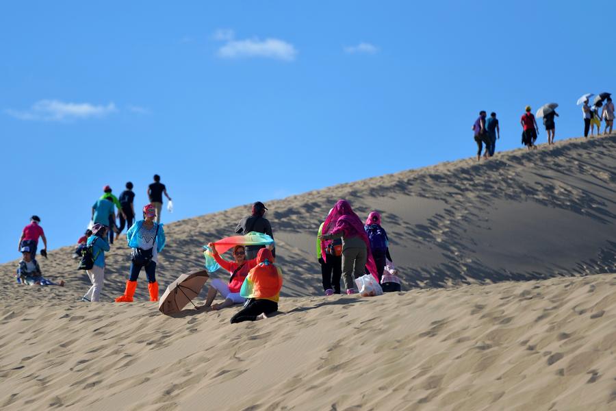 Tourists visit Mingsha Mountain in Dunhuang, NW China